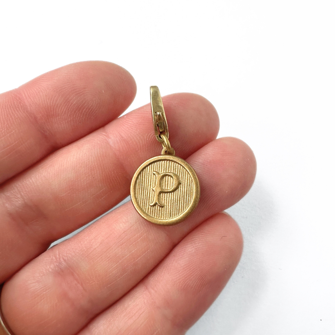 Small circular gold tone letter "P" charm