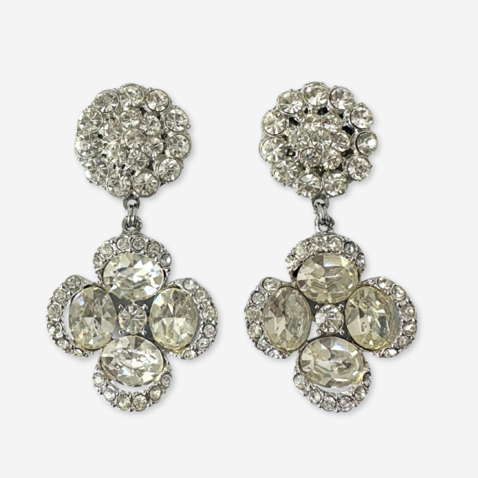Pair of silver earrings with clear gemstones on a white background