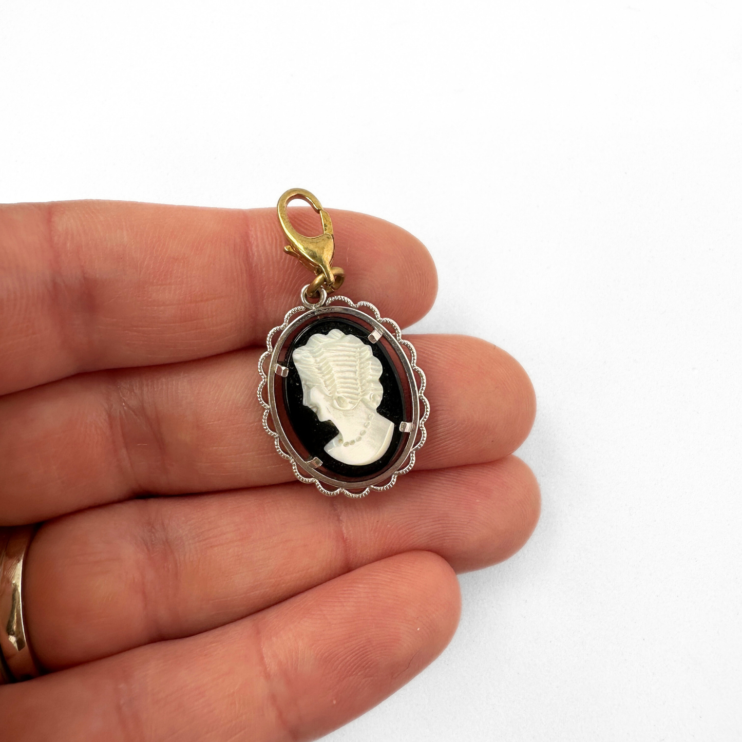 Vintage black and white cameo charm with silver setting and brass clasp