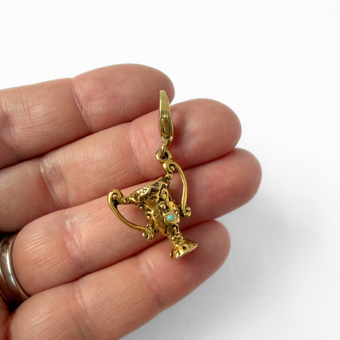 Vintage aged gold trophy charm with turquoise stone