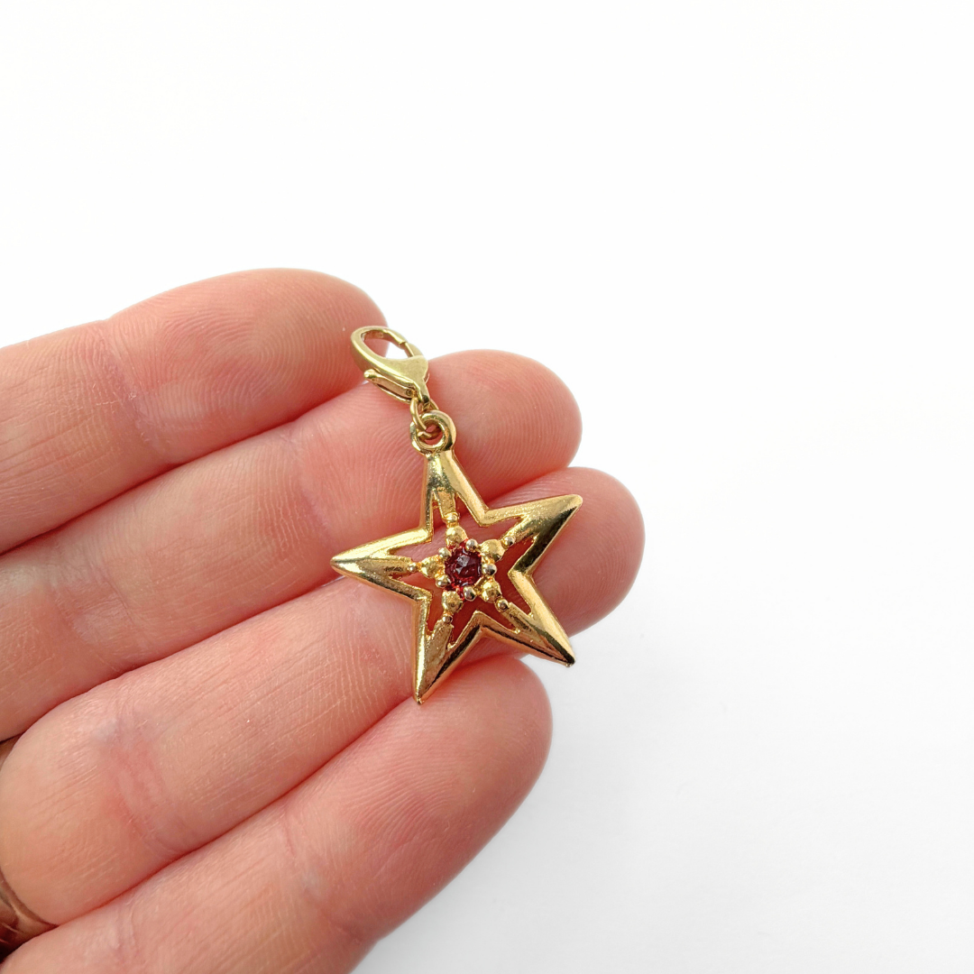 Vintage small gold plated star charm with red center