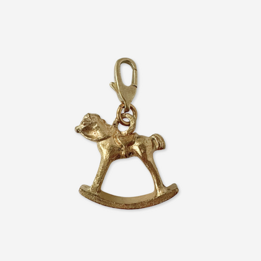 Gold rocking horse charm on a white background