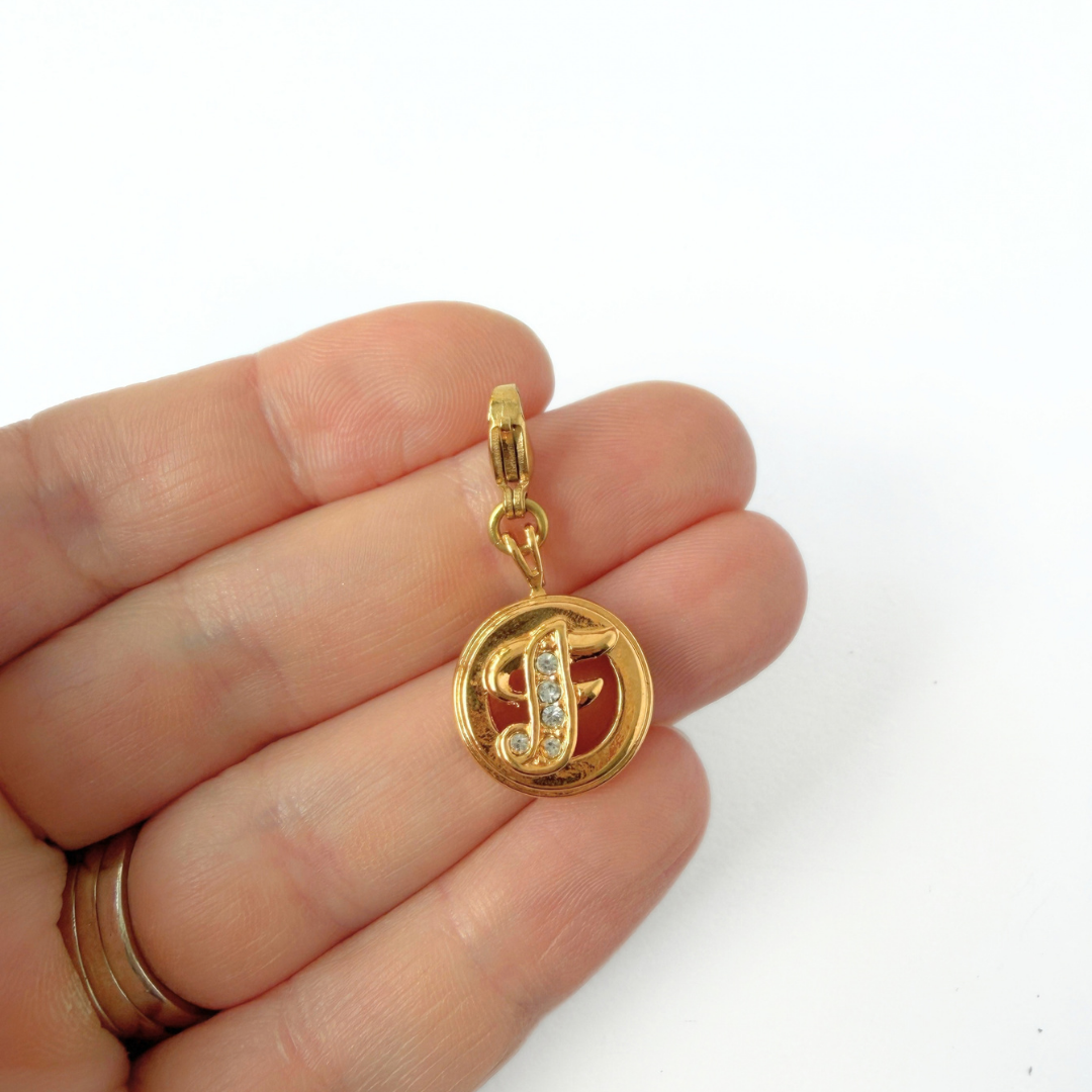 Small circular gold and rhinestone letter "F" charm