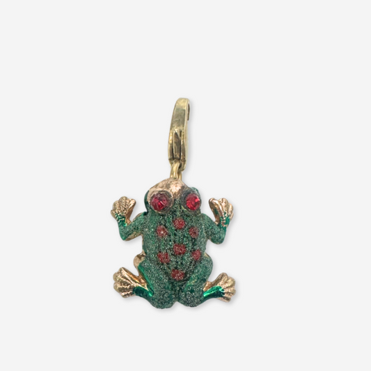 Gold and green frog pendant with red gemstones on a white background