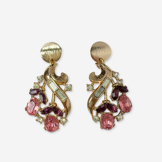 Pair of gold earrings with pink and purple gemstones on a white background