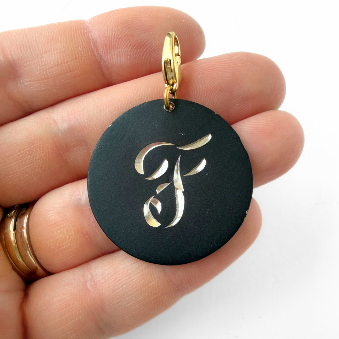 Large vintage black matte circular "F" monogram charm