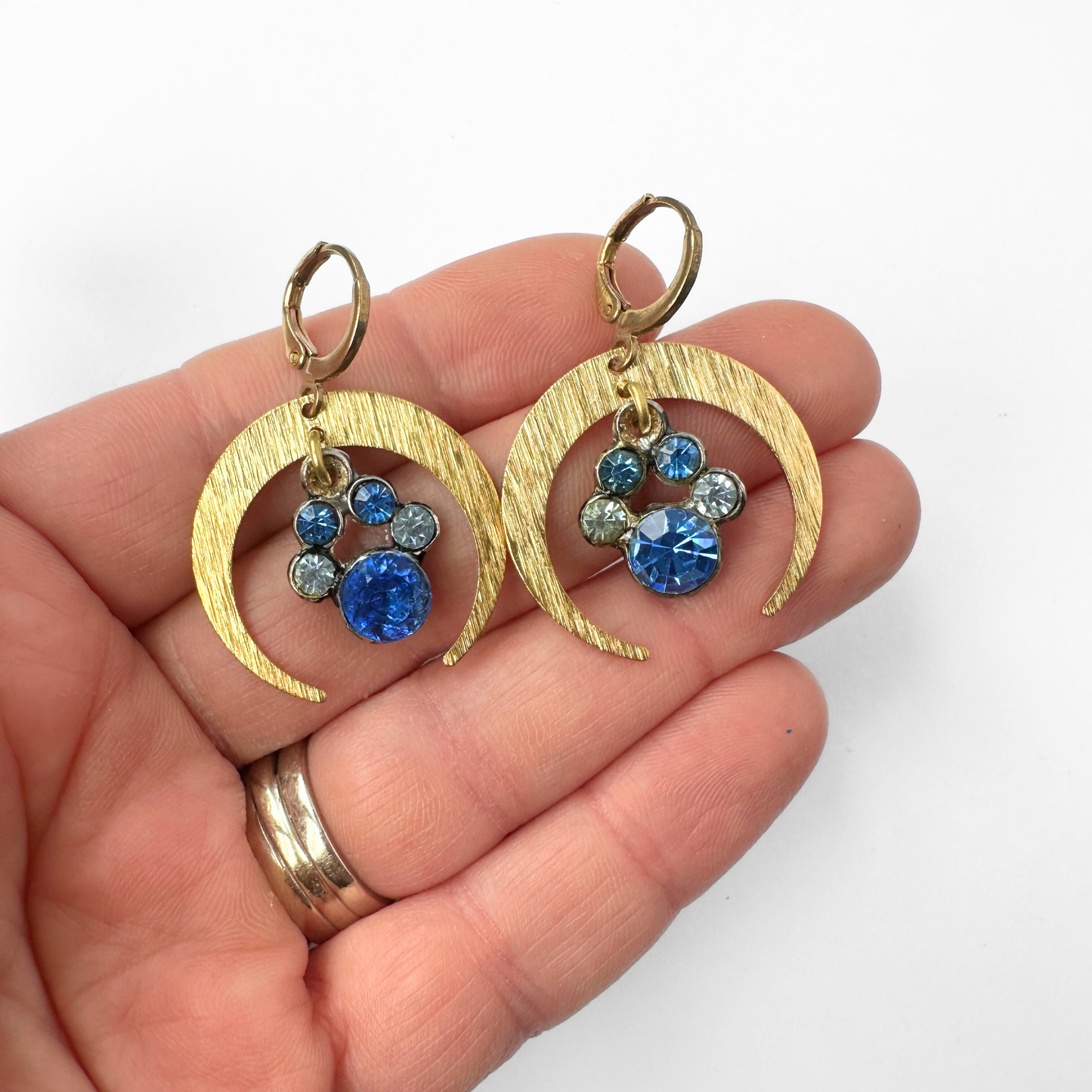 Brass crescent hoop earrings with vintage blue rhinestone center drops