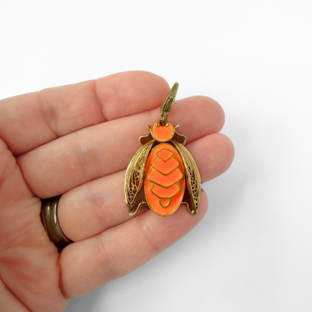 Large vintage gold and neon orange enamel insect charm
