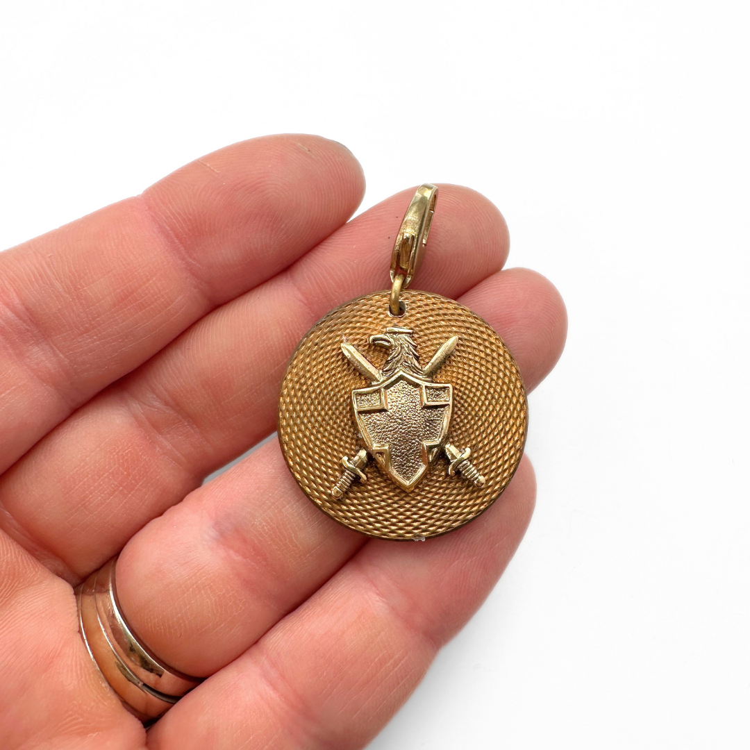 Antique gold textured French button charm with shield embellishment