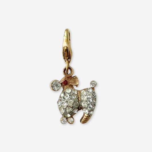 Gold dog-shaped pendant with gemstones on a white background