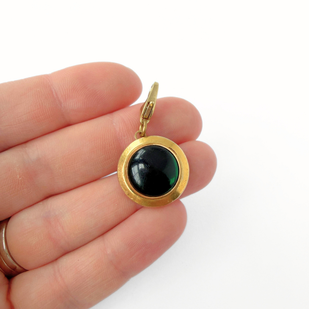 Vintage gold plated circular charm with green glass center