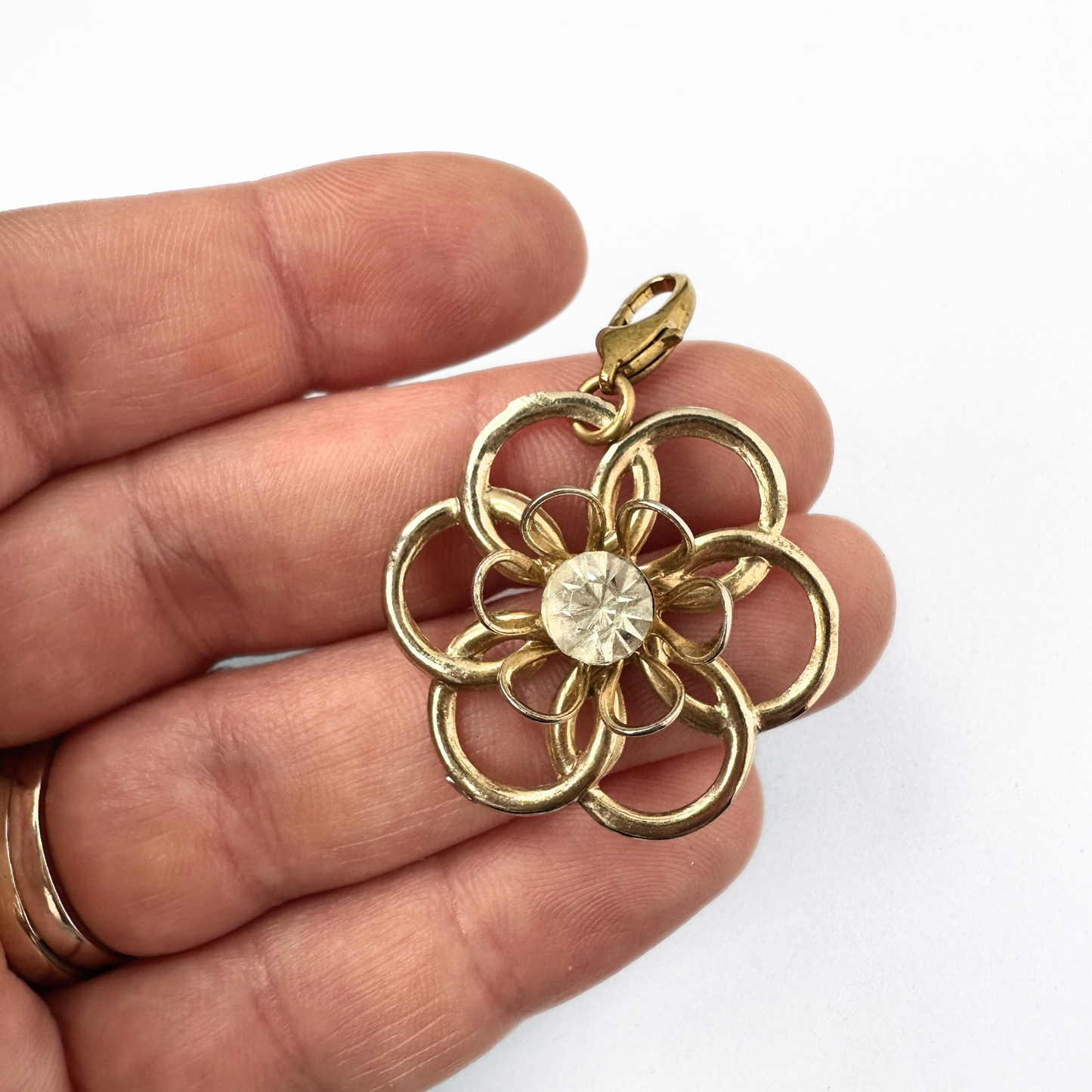 Vintage gold tone open flower charm with rhinestone center