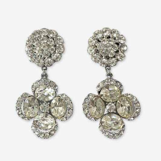 Pair of silver earrings with clear gemstones on a white background