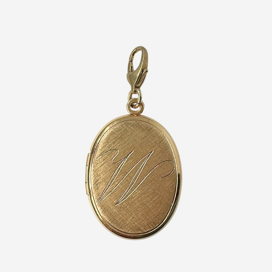Gold pendant with engraved initials on a white background