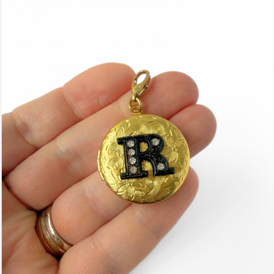 Vintage brass circular locket charm with black rhinestone letter "R"