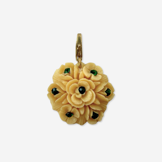 Vintage pale yellow carved celluloid flower charm with green rhinestones