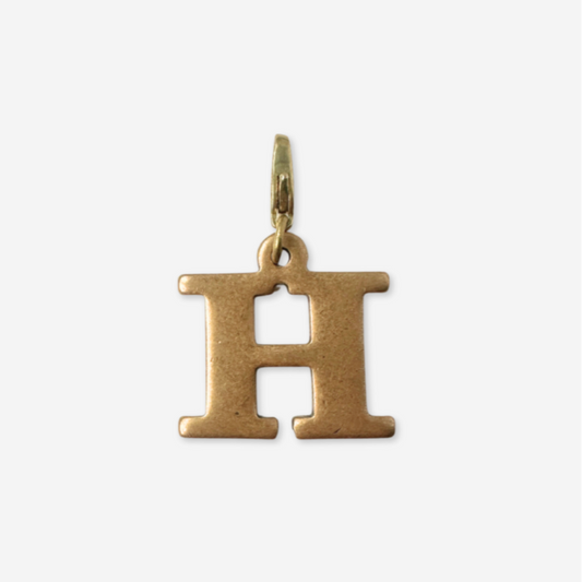 Gold letter 'H' pendant on a white background