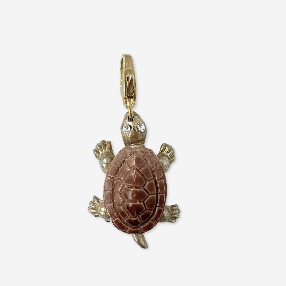 Gold turtle pendant with a brown shell on a white background