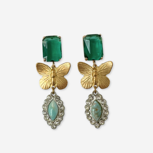 Butterfly earrings with green gemstones and gold accents on a white background