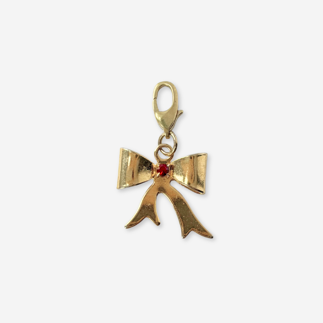 Vintage small gold plated bow charm with red center