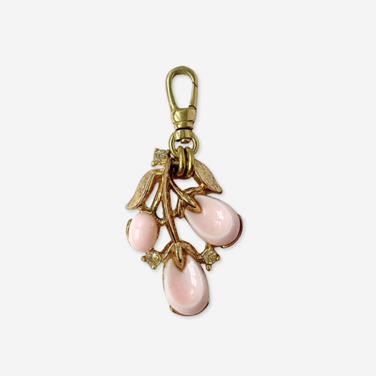 Gold charm with pink teardrop-shaped stones on a white background