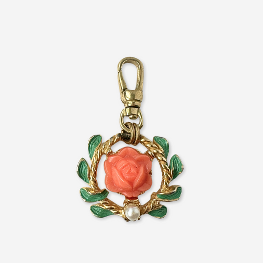 Gold keychain with coral rose and green leaves on a white background