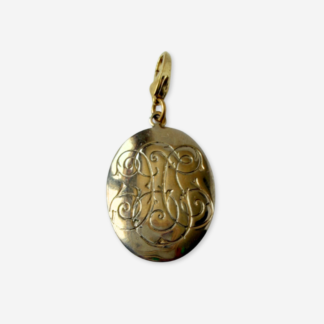 Vintage gold tone decorative monogram-like oval charm
