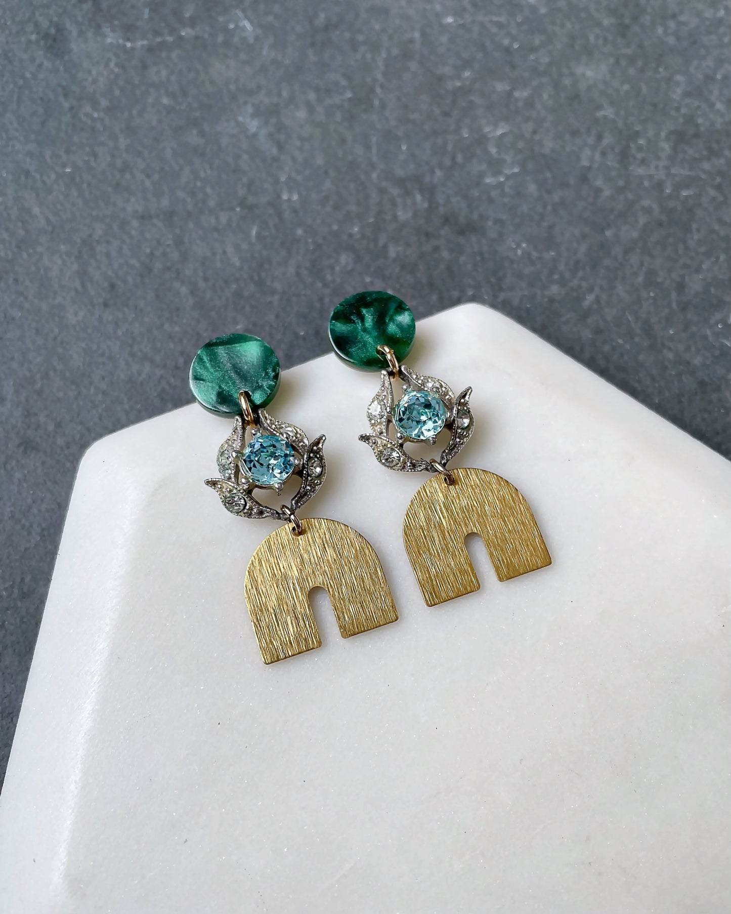 Vintage aqua rhinestone earrings with brass rainbow and green post